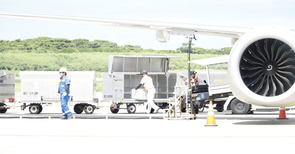 航空機のそばで貨物を取り扱う作業員