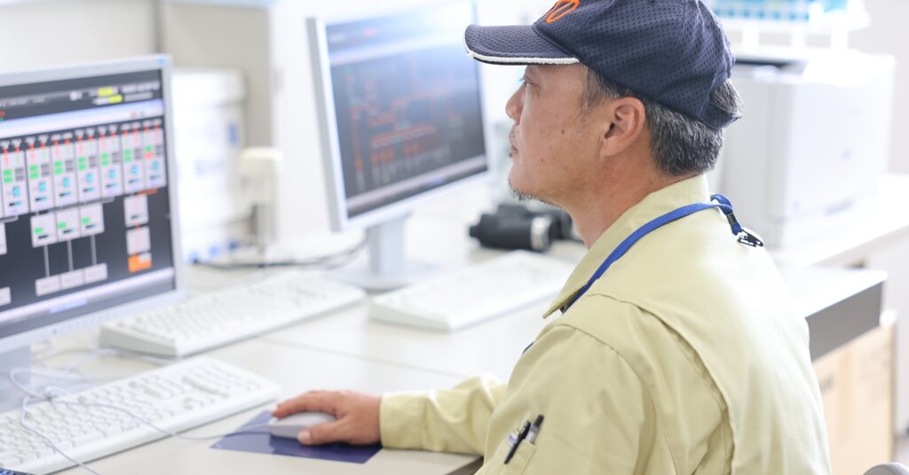 モニターで設備を監視する作業員